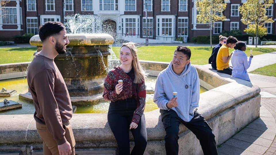 Students sitting at the fountain on campus